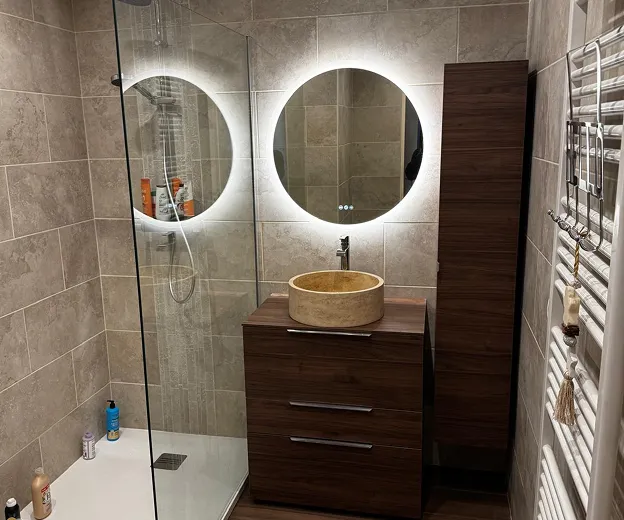 Salle de bain moderne avec douche vitrée, meuble vasque en bois, miroir lumineux rond à Longnes dans les Yvelines 78